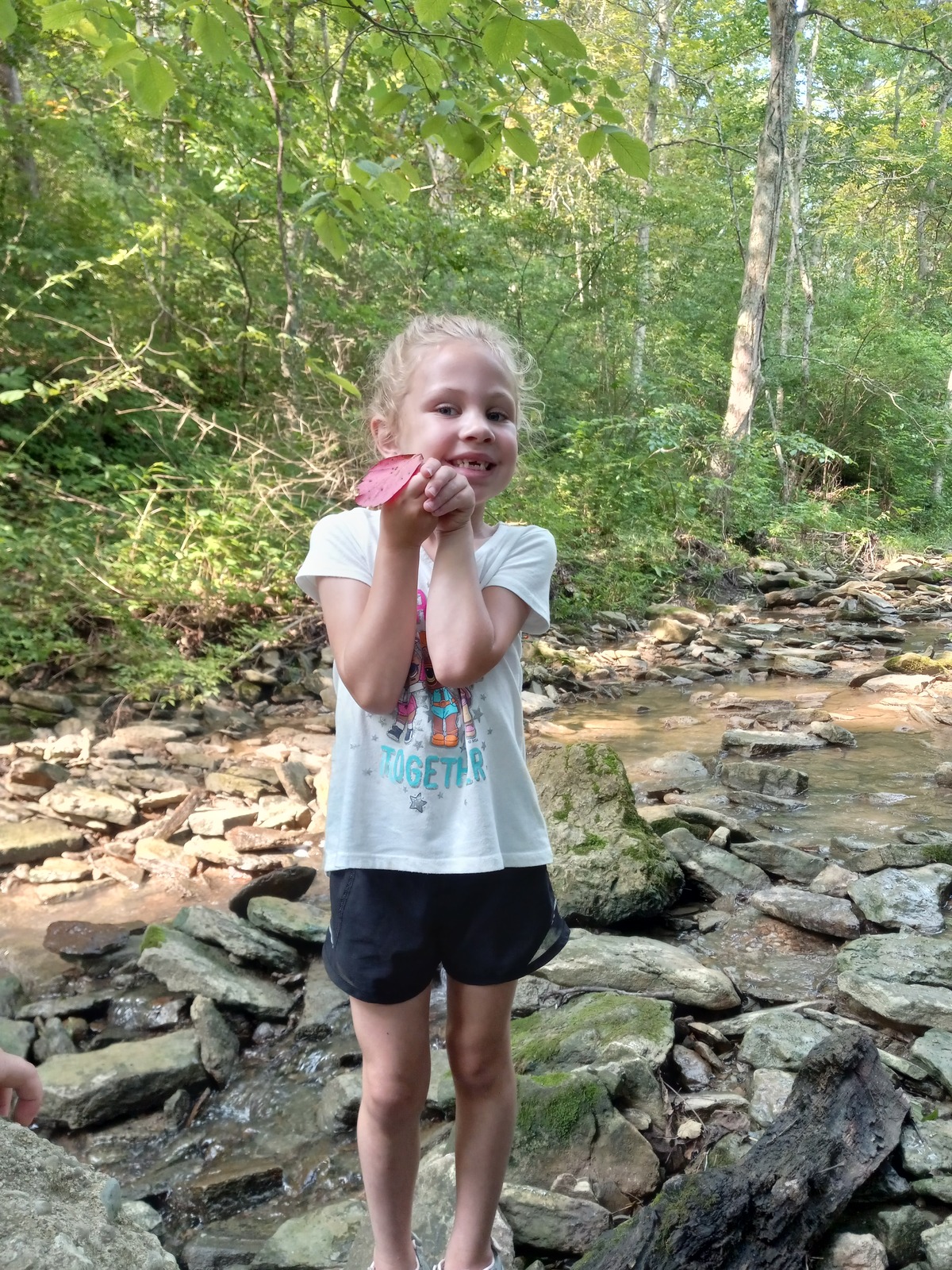 Child shows a leaf she found.